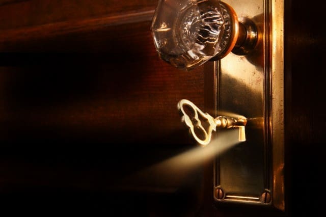 Brass key unlocking a door --- Image by Â© Steve Cicero/Corbis
